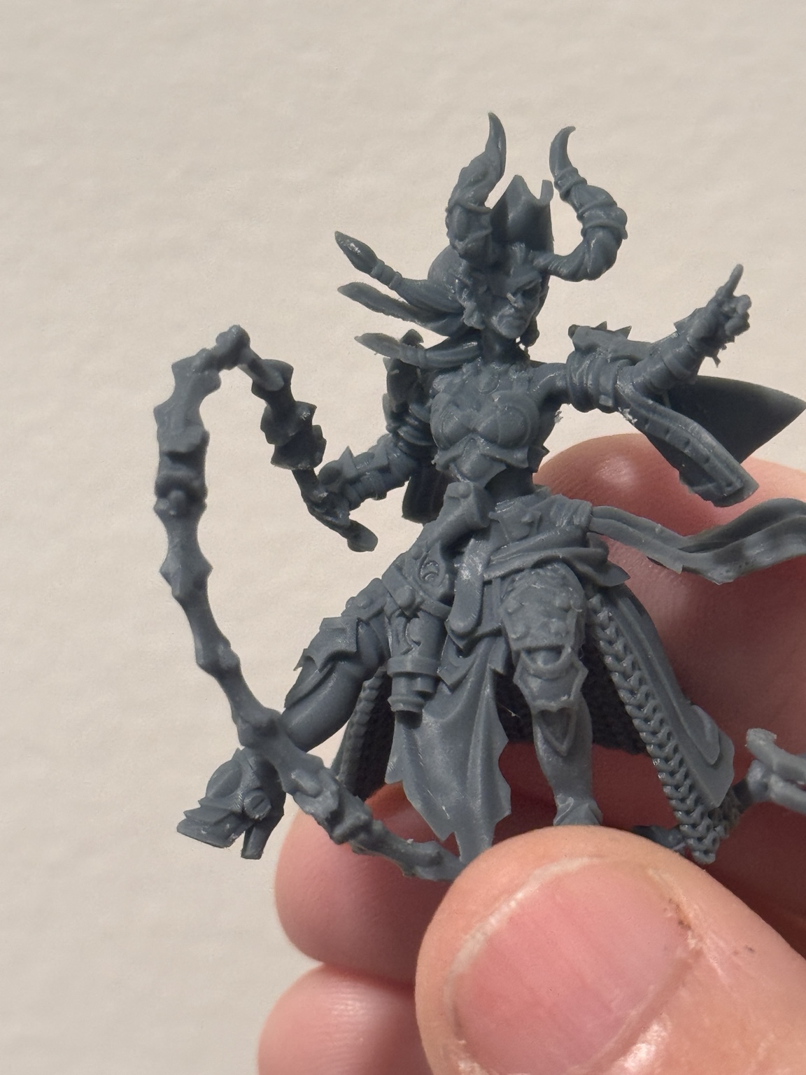 Unpainted horned Dread Armada model with a whip and a flowing cape