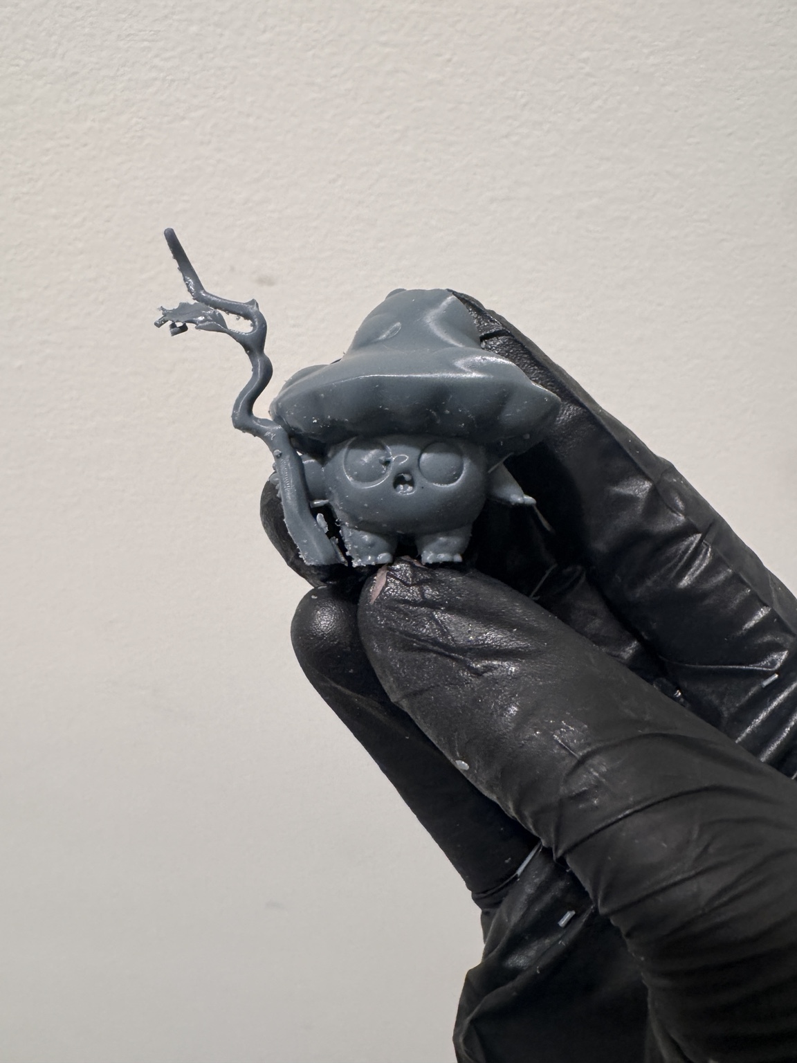 Close-up of an unpainted mushroom-themed miniature holding a staff